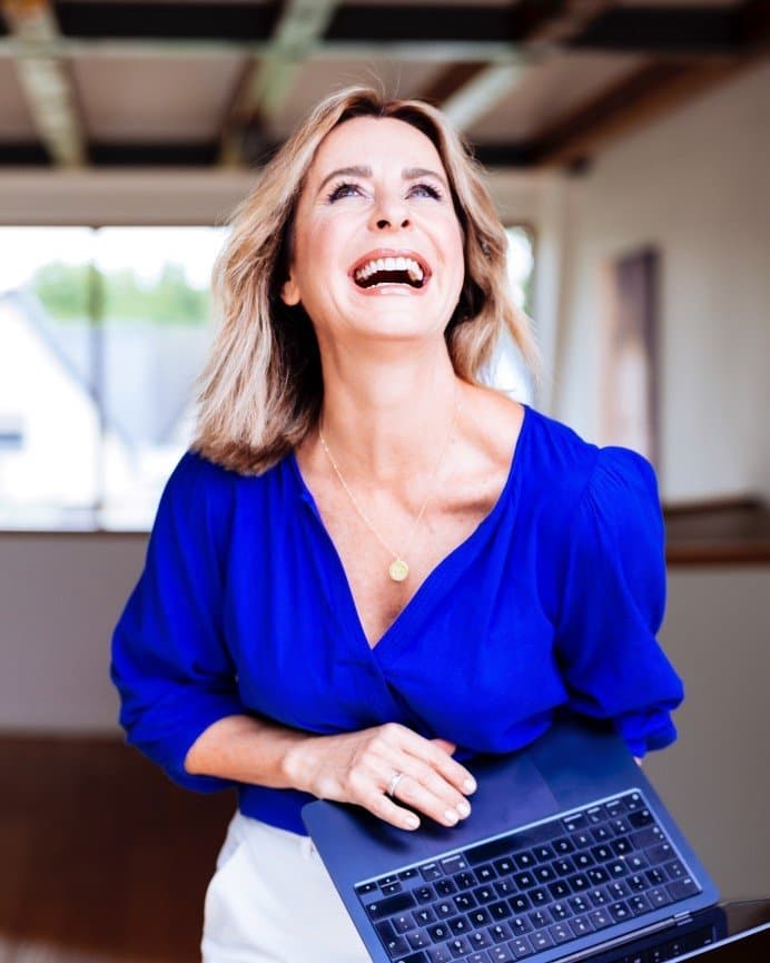 Bettina Cramer lachend im blauen Blazer